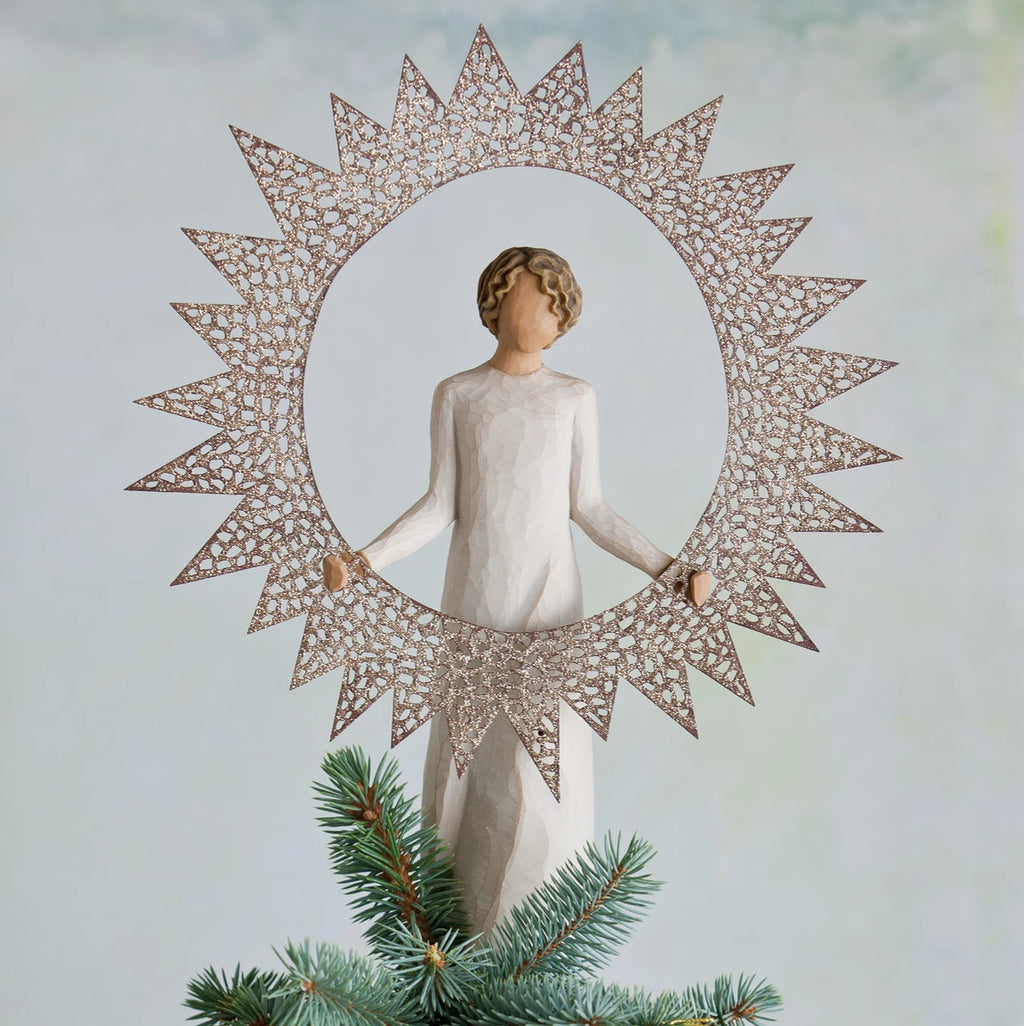 Faceless woman figurine wearing white standing holding round sun figurine around her body