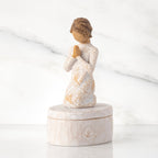Cream oval resin box, 3-D figure in prayer pose atop lid, in cream dress carved with birds and flowers