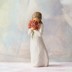 Willow Tree Surrounded by Love, 5"h hand-painted standing resin figure in cream dress, holding large bouquet of red-orange poppies up to face, in front of pastel painting