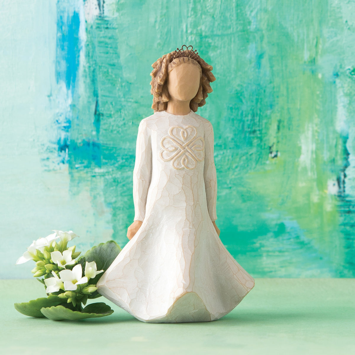 Willow Tree Irish Charm, 5.5" hand-painted dancing resin figure in cream dress with full skirt carved with stylized Celtic knot, arms down to sides, wire crown of hearts, in front of blue-green painting