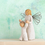Willow Tree Guardian Angel, 5”h hand-painted resin figure in cream dress and wire wings, holding hands of toddler in cream onesie walking ahead, in front of a green painting