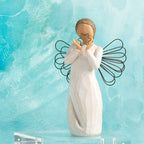 Willow Tree Bright Star, 6”h hand-painted standing resin angel figure in cream dress with wire wings, holding glittered wire star, in front of aqua painting