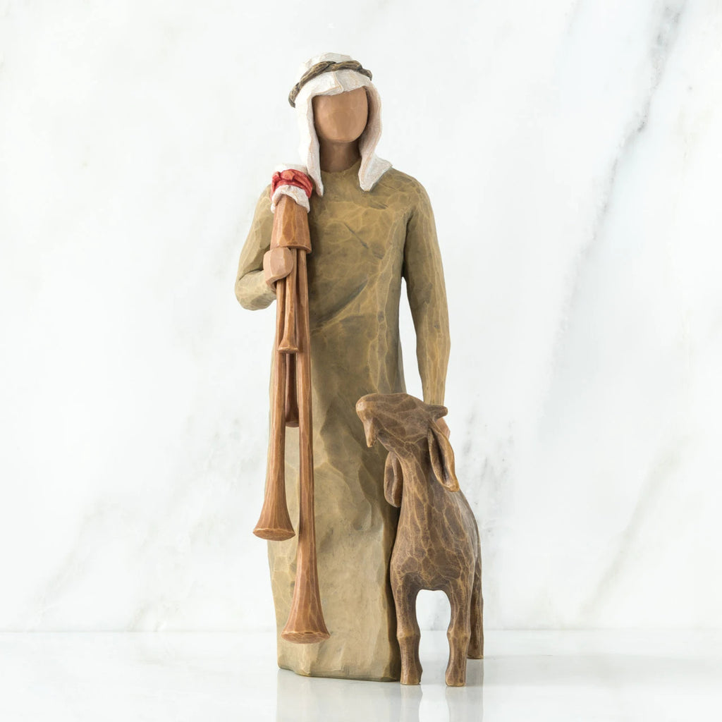 Wise man figurine standing in light brown attire with white headpiece, brown sheep at his feet