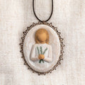 Oval bas-relief carving of figure holding sprig of rosemary, edged in pierced-metal filigree with brown elastic ornament loop