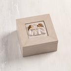 Cream wood box with hinged lid. Inset bas-relief plaque of two seated girls, facing each other.