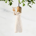 Figure in cream dress, holding white dove on extended arms. Hook and loop affixed to figure's head