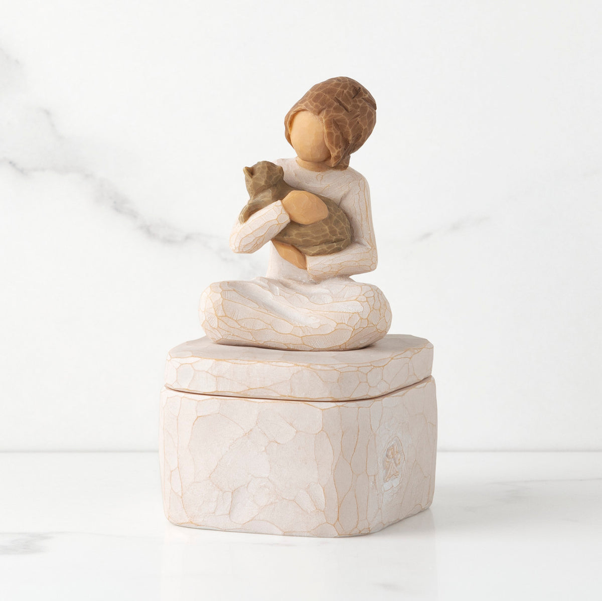 Front: cream square resin box with lid, 3-D figure of seated girl holding cat atop lid