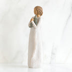 Side view of brunette girl figurine in white dress holding triangle figurine