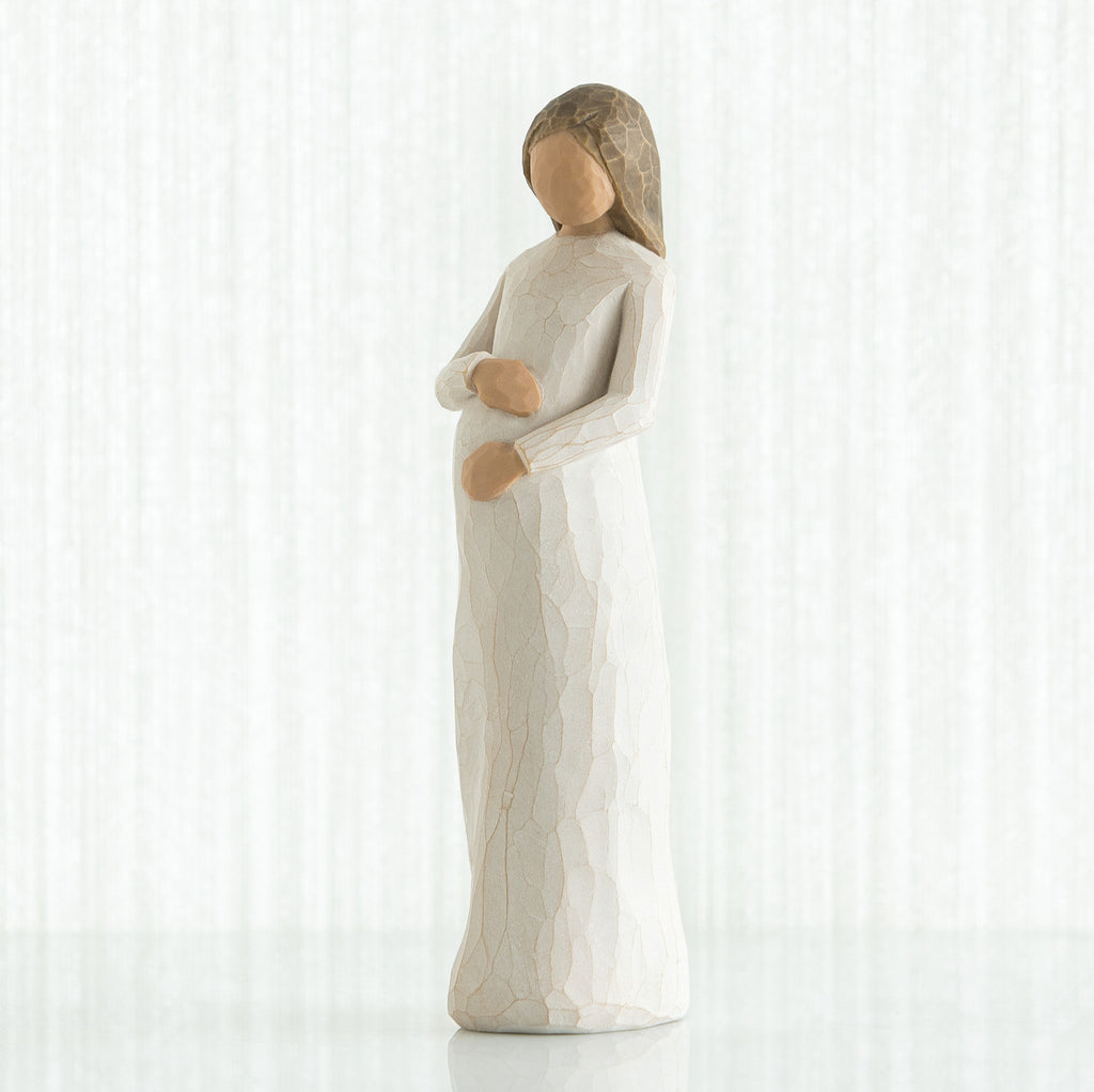 Brunette woman figurine in white holding her stomach facing forward