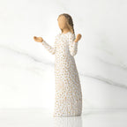 Side view of brunette girl figurine in white dress with gold dots holding her hands up
