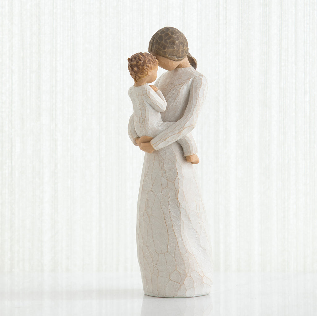 Mother figurine in white dress with brunette hair holding baby in white