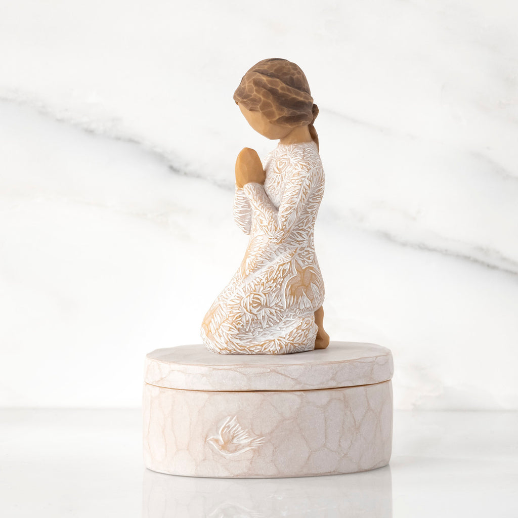 Left side: cream oval resin box, 3-D figure in prayer pose atop lid, in cream dress carved with birds and flowers