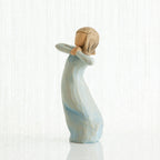 Small girl figurine in light blue dress standing with her hands up