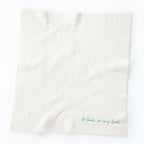 Overview of white towel with 'so loved, so very loved' in light blue in the right corner