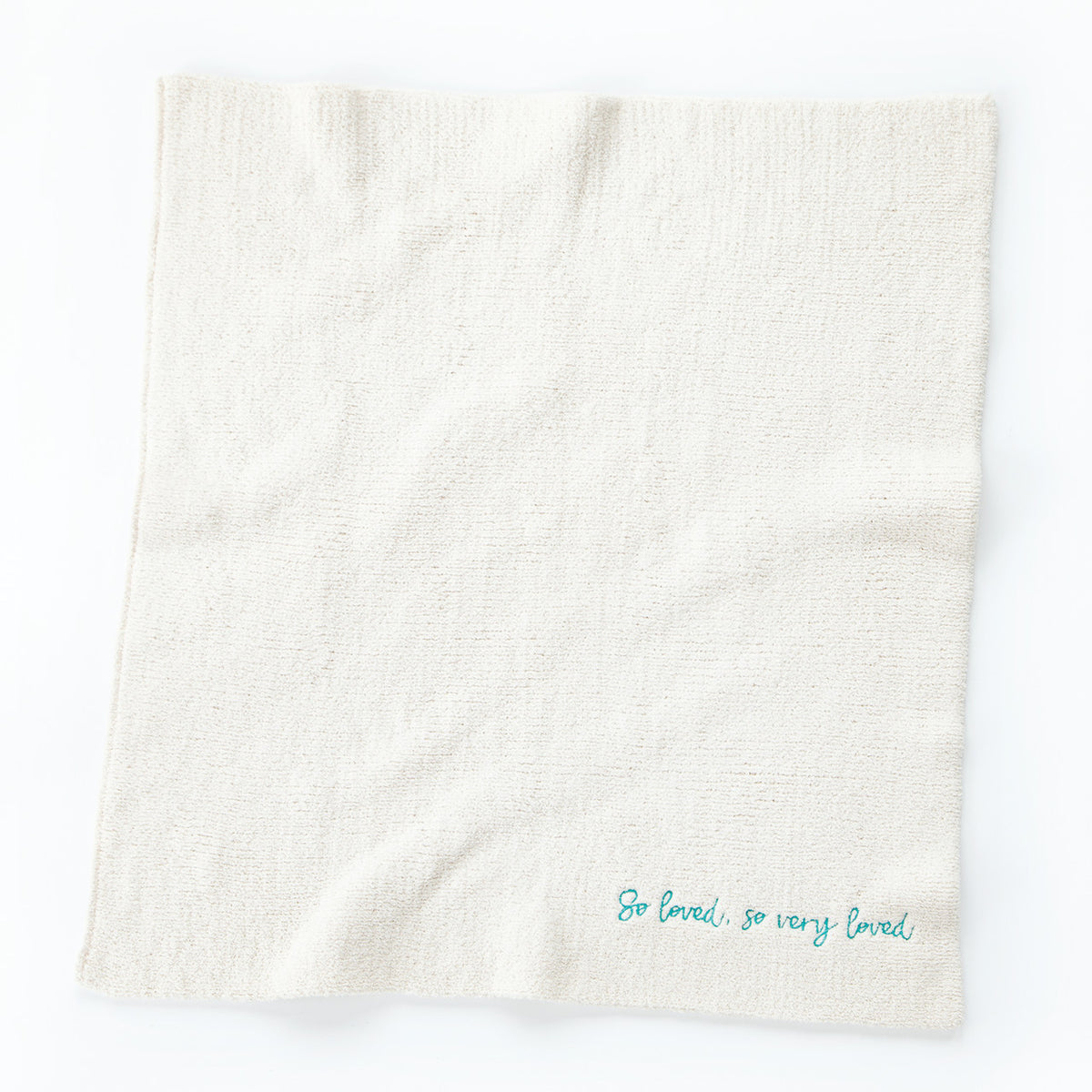 Overview of white towel with 'so loved, so very loved' in light blue in the right corner