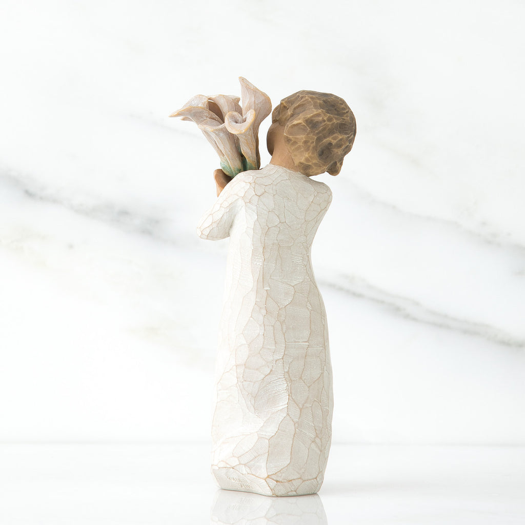 Back view of lIttle girl with short brown hair holding a cluter of white calla lilies