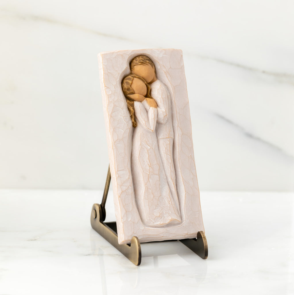 Willow Tree Embrace Plaque, 5.75”h x 2.68”w x .5”d hand-painted resin bas-relief carving of embracing couple. Plaque displayed on Plaque Stand on marble