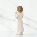 Back view of brunette girl figurine in white dress
