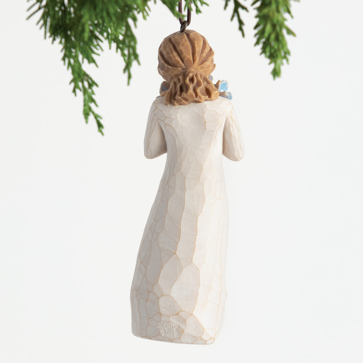 Back view, female figure in cream dress, holding bouquet of blue forget-me-not flowers to face. Hook and loop affixed to head