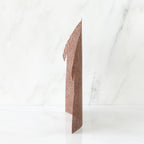 Brown figurine standing up against white background