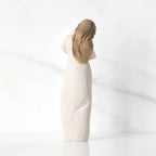 Back view of brunette girl figurine in white dress and has gold dots in her hair
