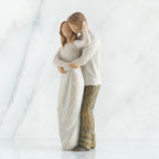 Man and woman couple figurines in white hugging another