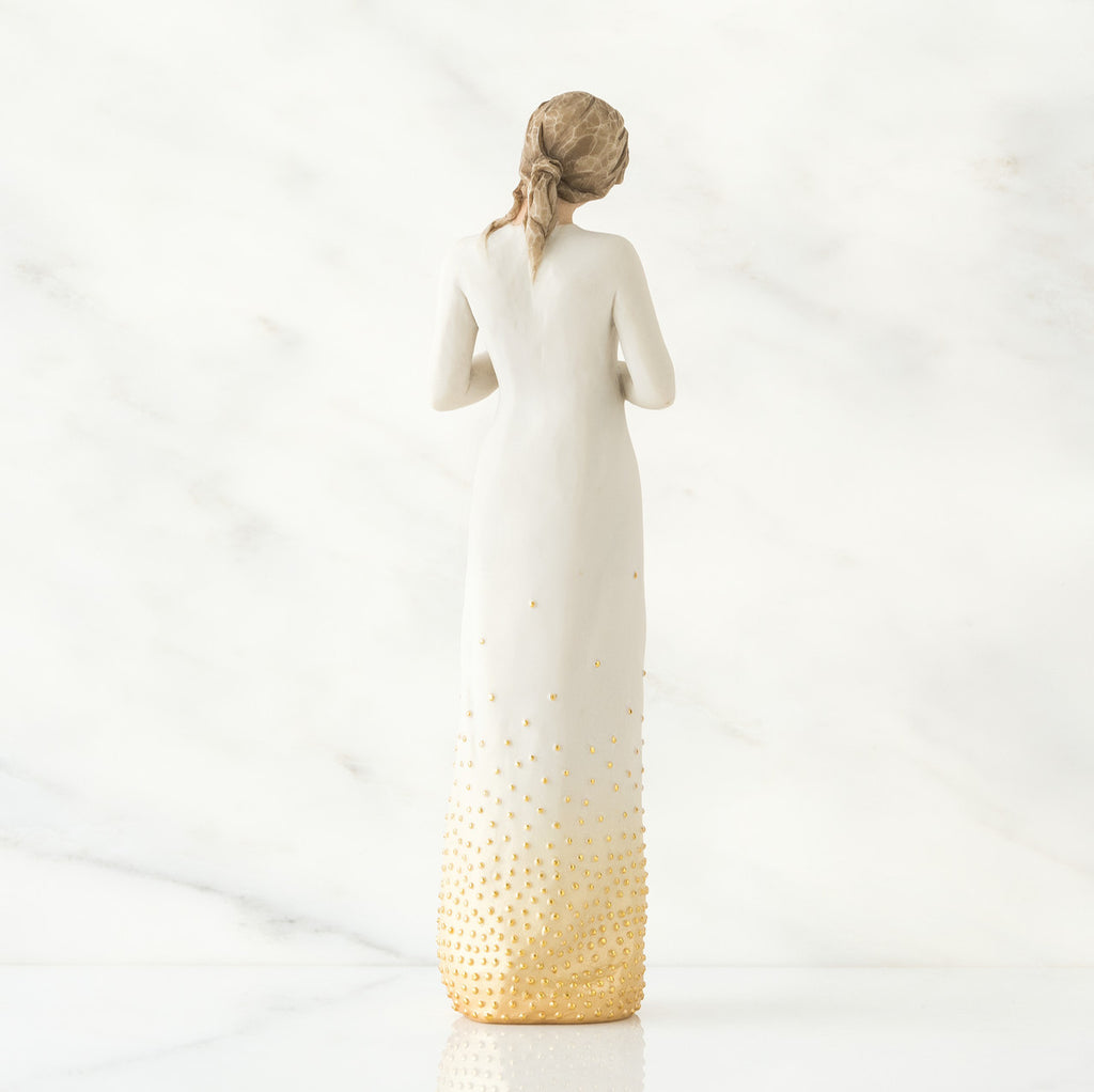 Back view of brunette woman wearing white dress with gold bottom