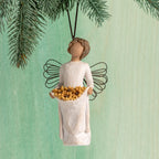 Front view: female figure with wire wings, holding skirt filled with yellow sunflowers; hook and loop affixed to head