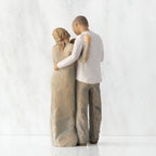 Back view of standing couple, woman has lighter skin and hair; man has darker skin and hair, holding a baby between them.