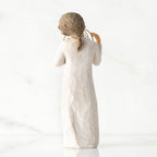 Back view, standing female figure in cream dress, holding gold wire circle in which is written 'love you'