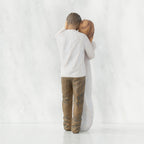 Back view of couple, standing with arms around each other. Woman has lighter skin and hair; man has darker skin and hair.