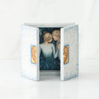White/blue open box with two man and woman figurines inside holding hands