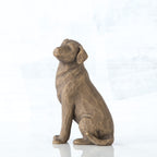 Dark brown dog figurine sitting from the side