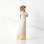 Right-facing view, standing figure in cream dress, holding arms to face in wistful gesture. Hair and dress embellished with gold dots