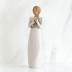 Faceless woman figurine standing facing forward wearing white dress holding star print napkin