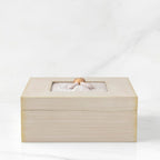 Side View: Cream square wood box with hinged lid, carving on lid of female in cream dress with hands in prayer position, surrounded by leaves and vines