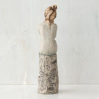 Back view of brunette girl sitting on grey rock
