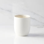 Inside view of unglazed off-white tapered cylinder ceramic candle showing sentiment written in gold along inside rim of vessel