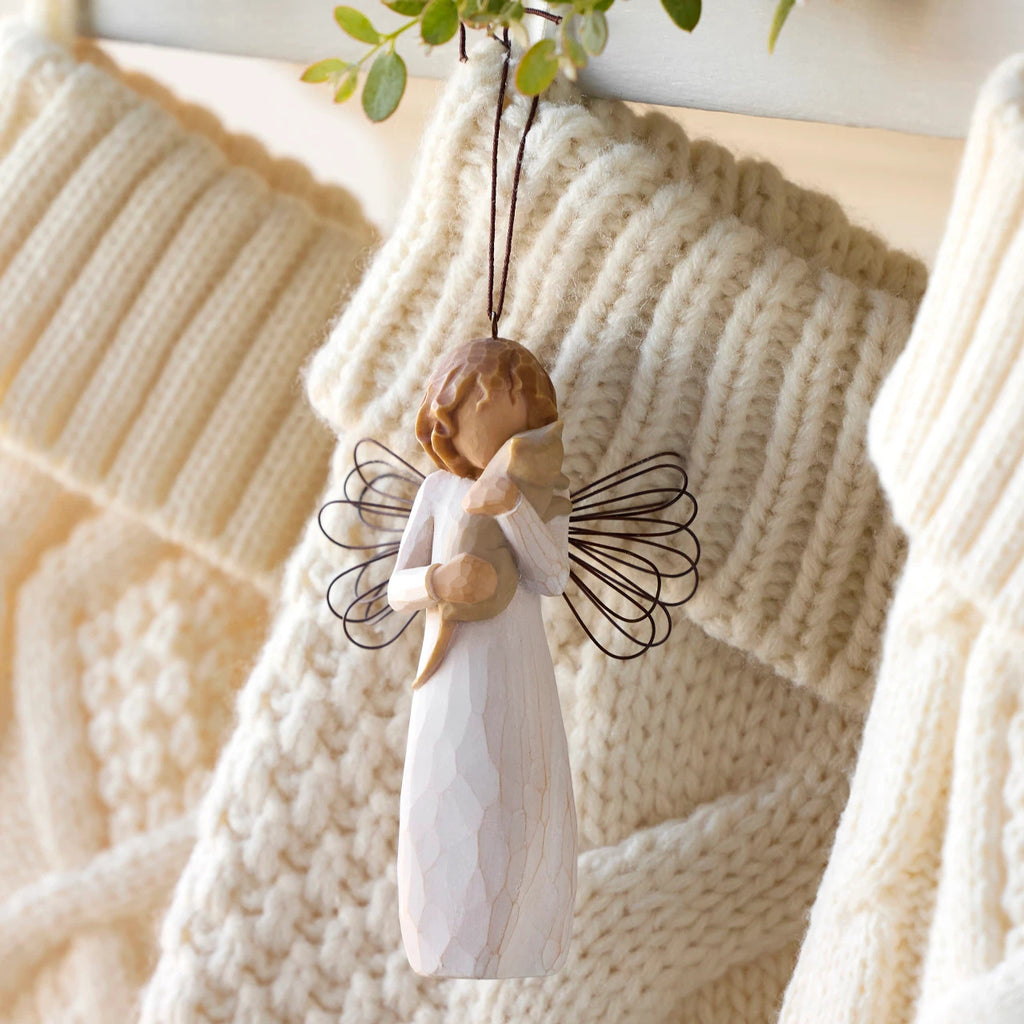 Willow Tree With affection Ornament, 4.5”h hand-painted resin figure in cream dress with wire wings, holding gray cat, brown elastic cord, hanging with cream knitted Christmas stockings