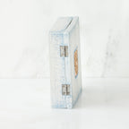 Side view of light blue/white wooden book standing up white background