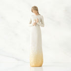 Brunette girl figurine in white dress holding white candle in one hand