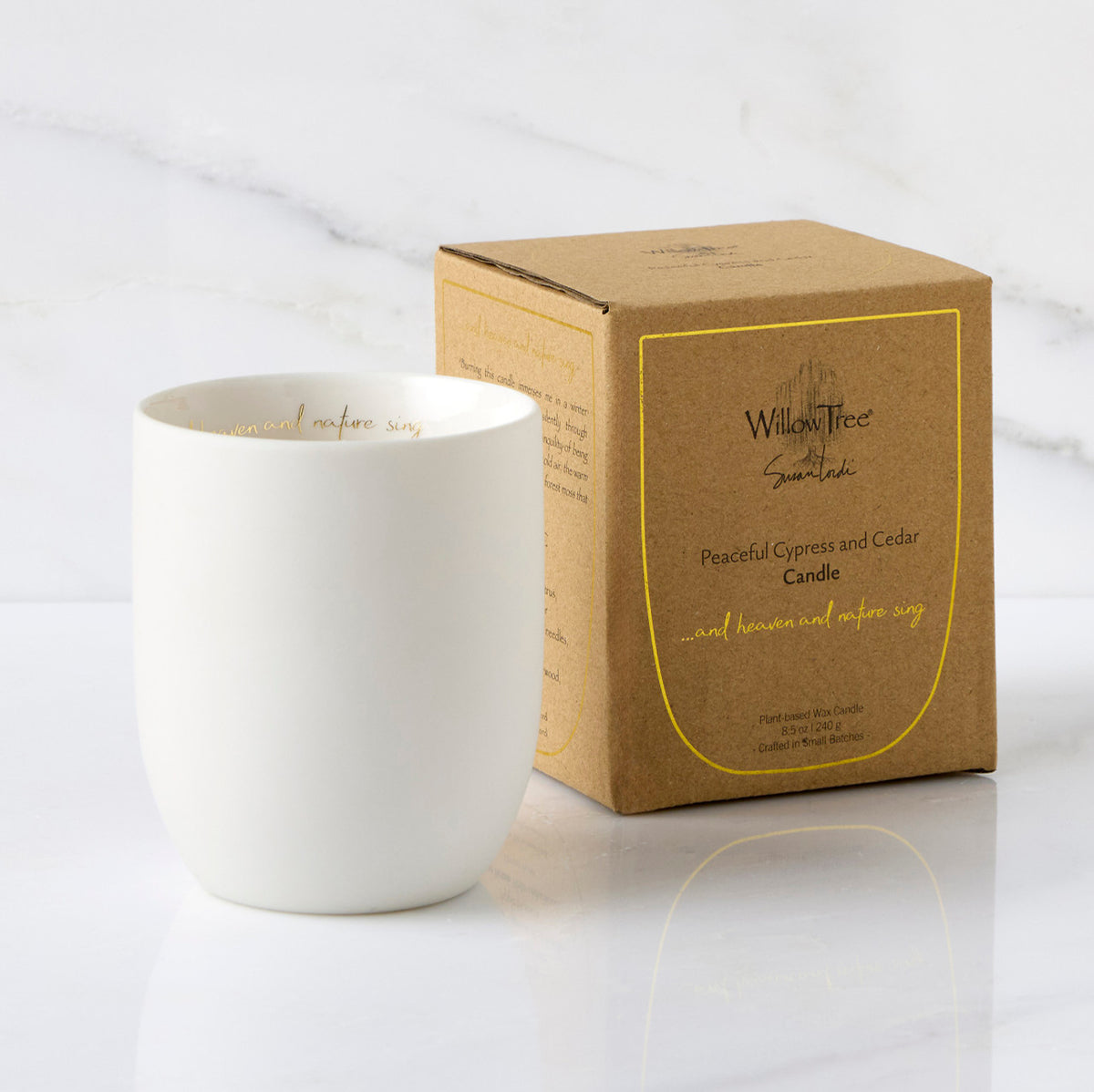 Filled scented candle with unglazed off-white tapered cylinder vessel, sentiment written in gold inside rim, plant-based wax blend, all-cotton wick, shown with packaging