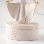 Detail view: back of oval resin box, showing carved butterfly detail on box base