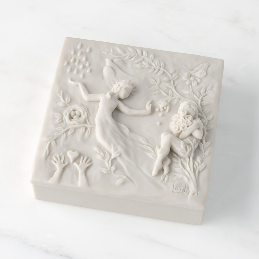Closed white resin square box; lid carved with figural and organic imagery