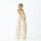 Mother faceless figurine hugging faceless daughter figurine - both standing wearing white dresses