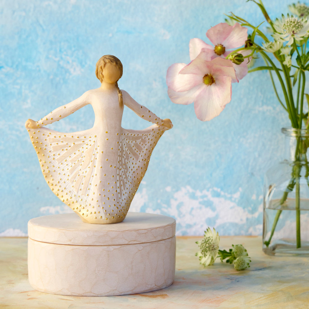 Willow Tree Butterfly Keepsake Box, 6.5"h x 4.5"h hand-painted oval resin box, 4.75”h figure holding cream skirt with carvings of monarch butterfly affixed to lid, open in front of sky blue painting