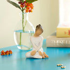 Willow Tree Serenity, 3.5”h hand-painted seated figure in cream dress, arms crossed in balletic pose, on blue table with books